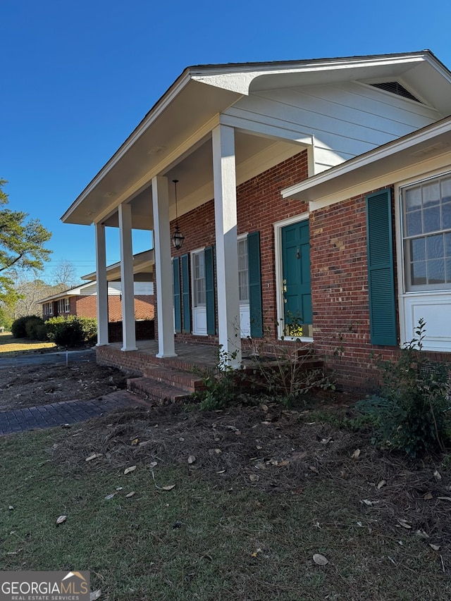 view of side of property featuring covered porch