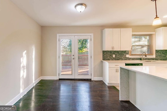 kitchen featuring sink, decorative light fixtures, and white cabinets