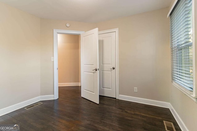 unfurnished bedroom with dark hardwood / wood-style floors