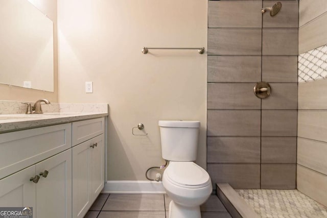 bathroom with vanity, a tile shower, tile patterned floors, and toilet