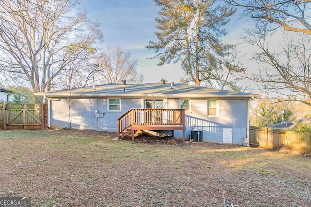 back of property with central AC unit and a deck