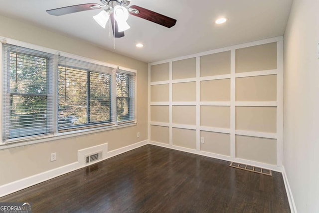 spare room with dark wood-type flooring, ceiling fan, and built in shelves