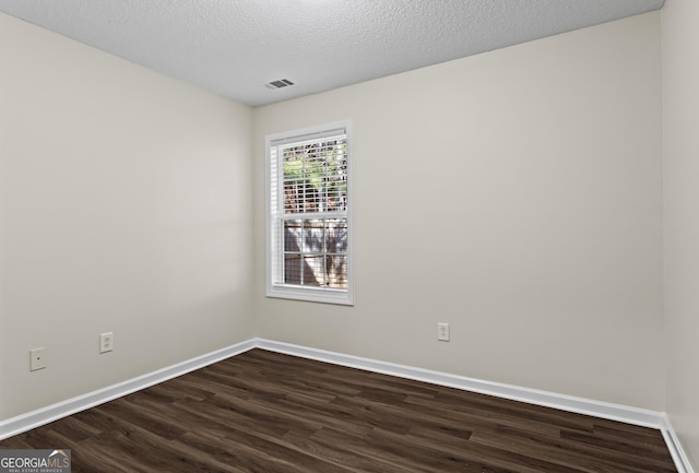 unfurnished room with dark wood-type flooring and a textured ceiling