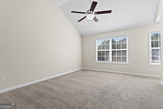 carpeted spare room with vaulted ceiling and ceiling fan