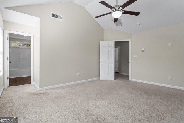 unfurnished bedroom with connected bathroom, high vaulted ceiling, light colored carpet, and ceiling fan