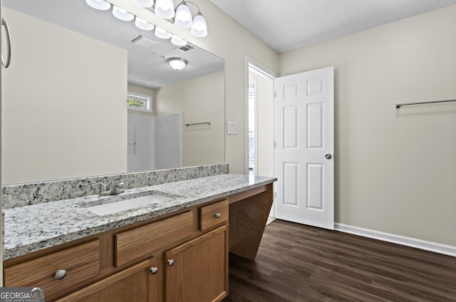 bathroom featuring vanity, hardwood / wood-style floors, and a shower