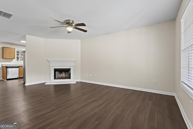 unfurnished living room with dark hardwood / wood-style floors, a textured ceiling, and ceiling fan