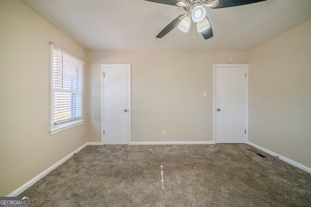 carpeted spare room featuring ceiling fan