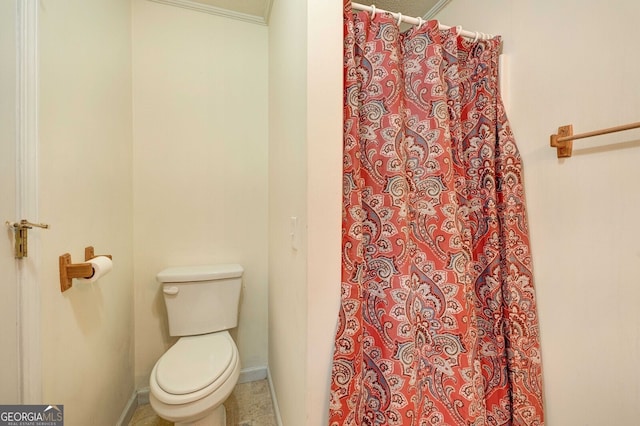 bathroom with ornamental molding, toilet, and a shower with shower curtain