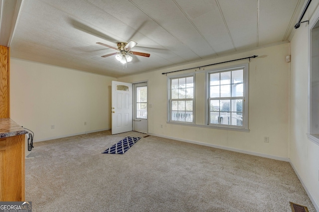 unfurnished room featuring ceiling fan, ornamental molding, and light carpet