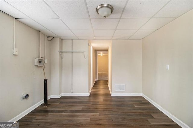 interior space featuring dark wood-type flooring and a paneled ceiling