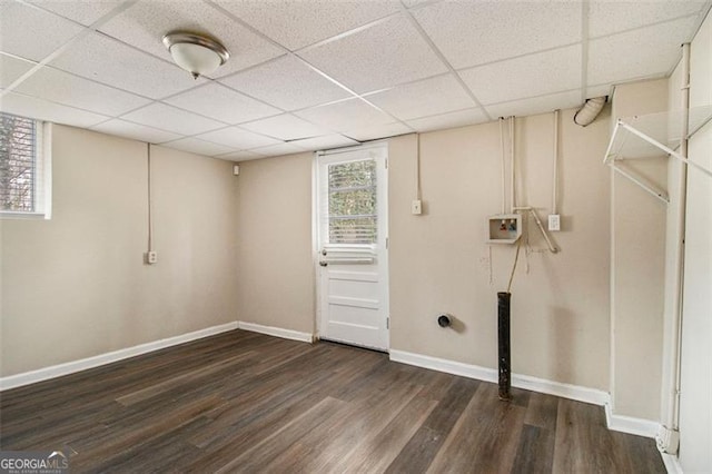 basement featuring dark wood-type flooring and a drop ceiling