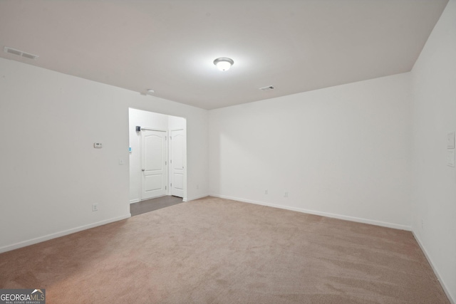 carpeted empty room featuring visible vents and baseboards