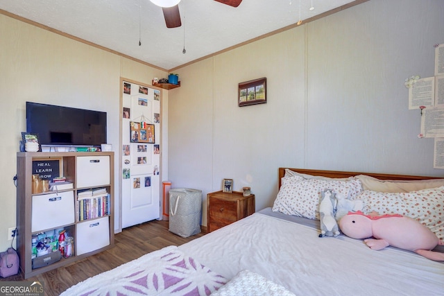 bedroom with dark hardwood / wood-style flooring, ornamental molding, and ceiling fan