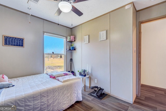 bedroom featuring hardwood / wood-style flooring, ceiling fan, crown molding, and a textured ceiling