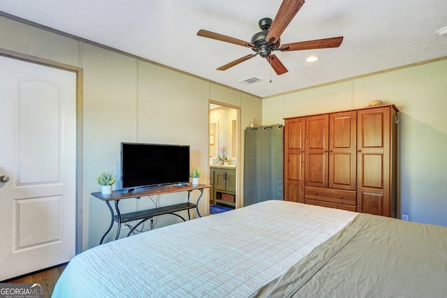 bedroom with dark hardwood / wood-style floors, ceiling fan, ornamental molding, and connected bathroom