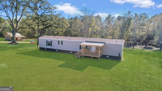 rear view of house with a wooden deck and a yard