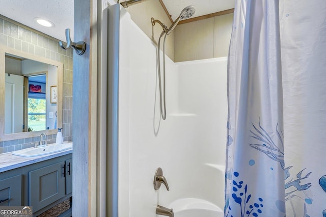 bathroom featuring vanity, shower / bathtub combination with curtain, and a textured ceiling