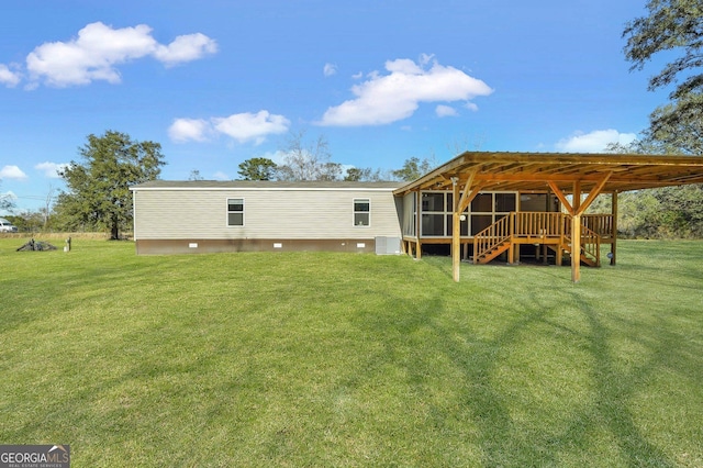 back of property featuring a wooden deck and a lawn