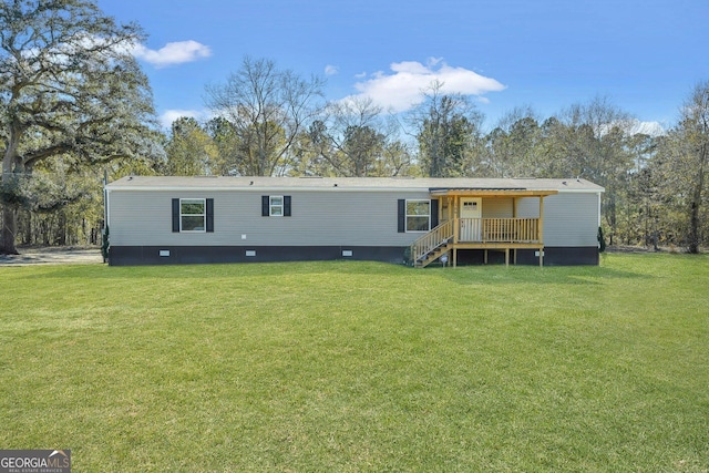 rear view of house featuring a wooden deck and a yard