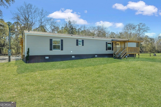 rear view of property featuring a lawn