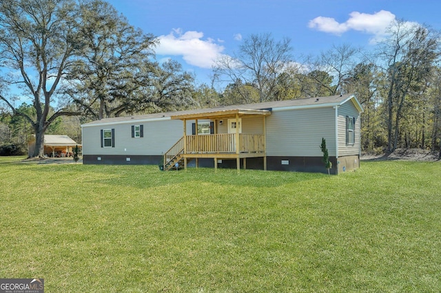 rear view of property featuring a lawn and a deck