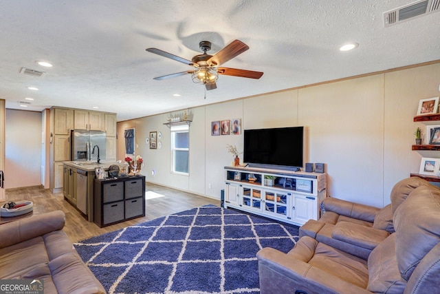 living room with ceiling fan, ornamental molding, dark hardwood / wood-style flooring, and a textured ceiling