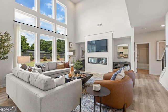 living room with a high ceiling and light wood-type flooring