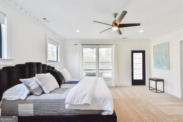 carpeted bedroom with multiple windows, crown molding, and ceiling fan