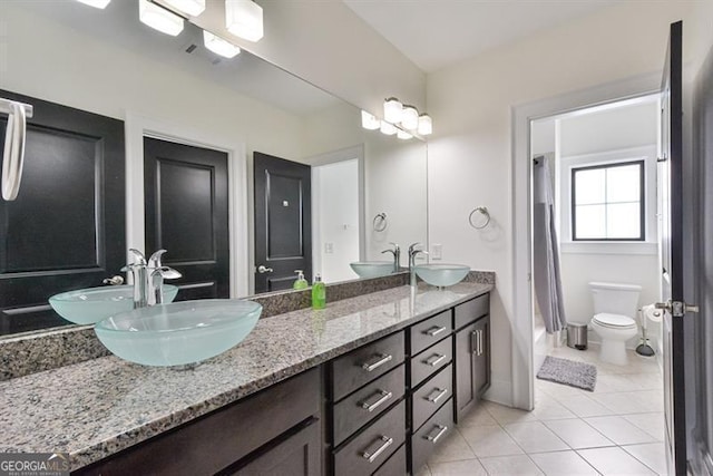 bathroom featuring tile patterned flooring, vanity, and toilet