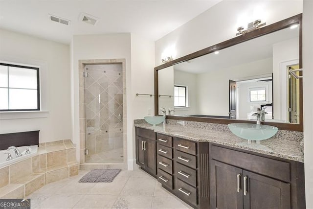 bathroom with tile patterned flooring, vanity, and plus walk in shower