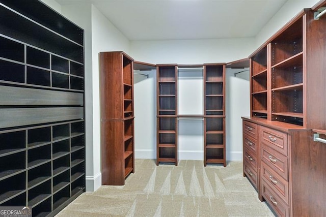 walk in closet featuring light carpet