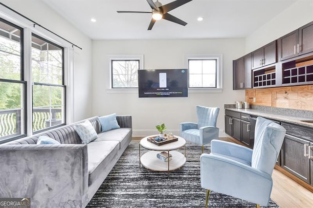 living room featuring ceiling fan and light hardwood / wood-style floors