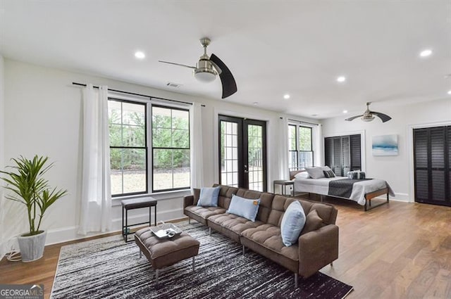 living room with hardwood / wood-style flooring, french doors, and ceiling fan