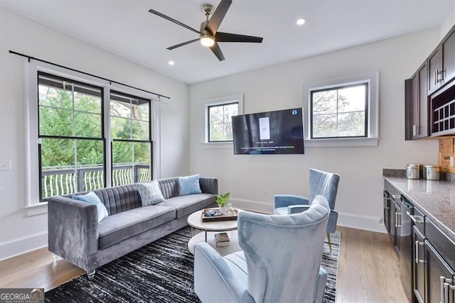 living room featuring ceiling fan and light hardwood / wood-style flooring