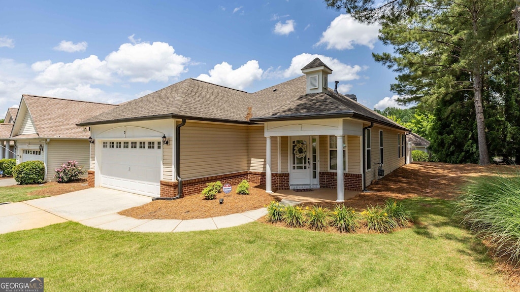 view of front of property featuring a garage, a front yard, and covered porch