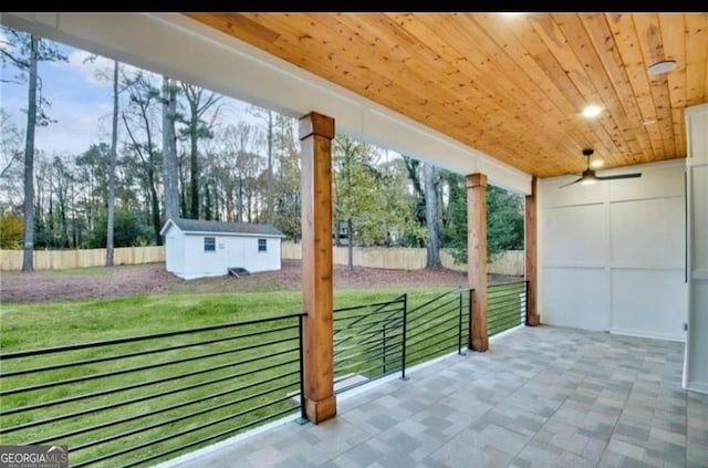 view of patio featuring ceiling fan and a storage shed