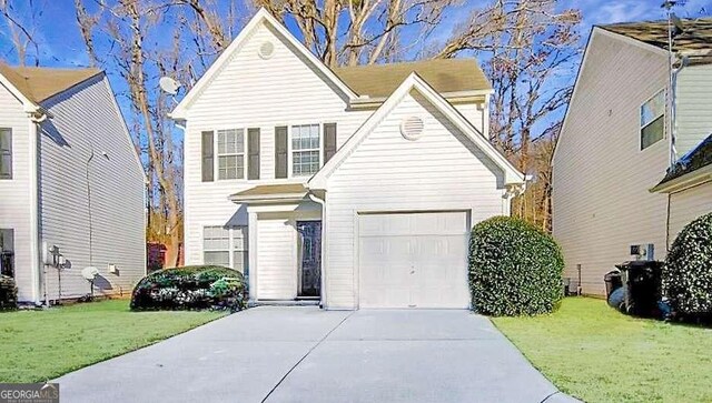 view of front property featuring a garage and a front yard