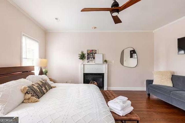 bedroom with ornamental molding, dark wood-type flooring, and ceiling fan