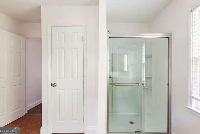 bathroom with a shower with shower door and wood-type flooring