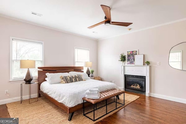 bedroom with ornamental molding, hardwood / wood-style floors, and ceiling fan