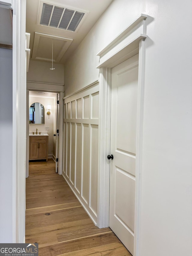 hall with sink and light hardwood / wood-style flooring