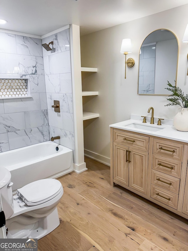 full bathroom featuring hardwood / wood-style floors, tiled shower / bath combo, vanity, toilet, and built in shelves