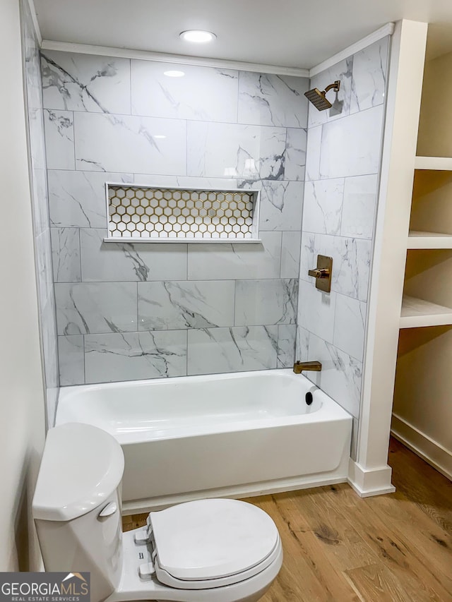 bathroom with hardwood / wood-style flooring, tiled shower / bath, built in features, and toilet