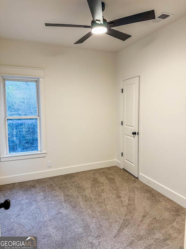 spare room featuring carpet and ceiling fan