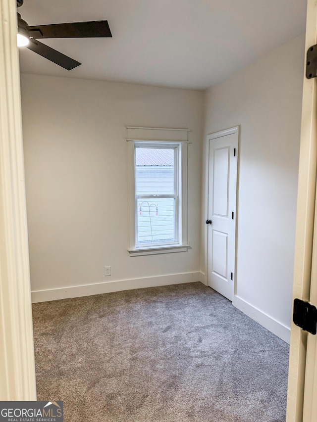 spare room featuring carpet and ceiling fan