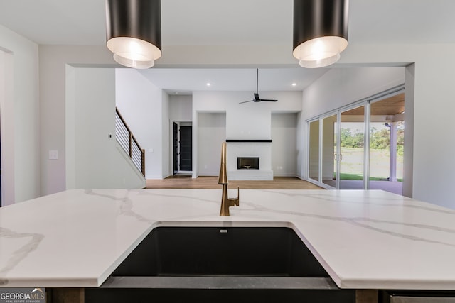 1593 Bethesda Church Rd, Carrollton, GA 30117 - kitchen featuring a sink, a brick fireplace, light stone countertops, ceiling fan, and open floor plan