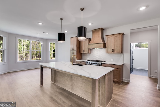 1593 Bethesda Church Rd, Carrollton, GA 30117 - kitchen featuring custom range hood, a sink, light wood finished floors, a kitchen island with sink, and tasteful backsplash