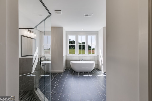 1593 Bethesda Church Rd, Carrollton, GA 30117 - bathroom with a soaking tub, walk in shower, tile walls, and marble finish flooring
