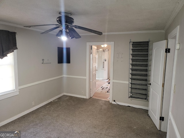 unfurnished room featuring crown molding, ceiling fan, carpet, and a textured ceiling